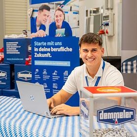 DEMMELER team member at the 2026 apprenticeship recruiting party in front of the banner "Starte mit uns in deine berufliche Zukunft"