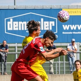 Header duel in front of the DEMMELER banner at FC Memmingen's stadium